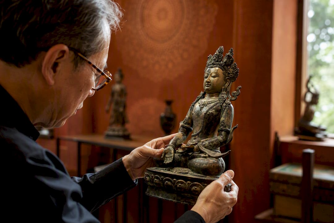Appraiser examining Asian bronze sculpture