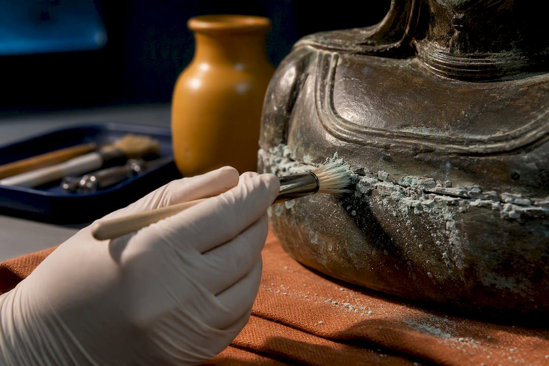 Conservator treating corrosion on bronze seam
