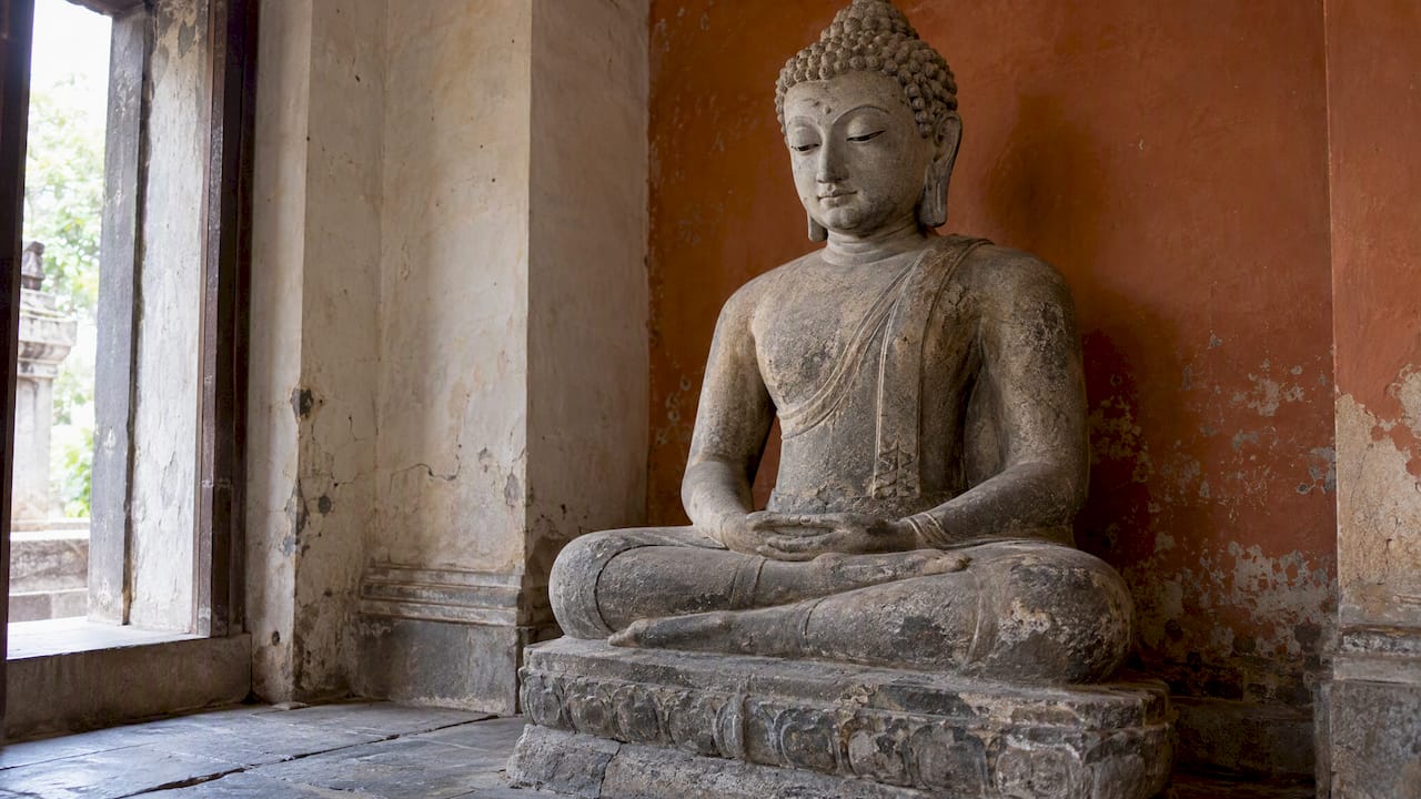 Stone Buddha statue with lowered eyes